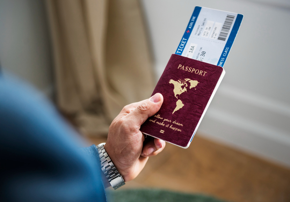 a man holding a passport and fly tickets