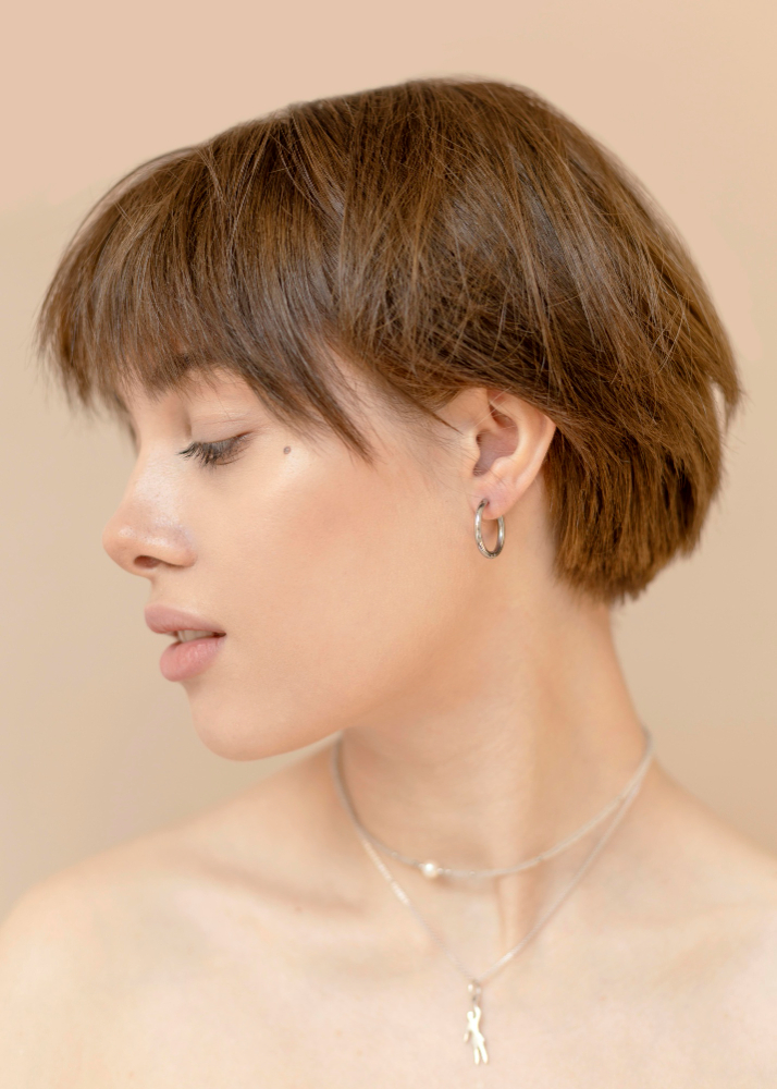a woman's side face with a small earring