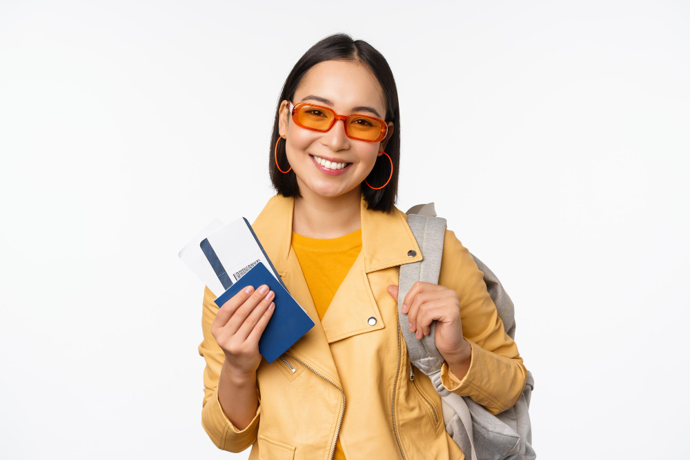 happy asian girl going on vacation holding passport and flight tickets