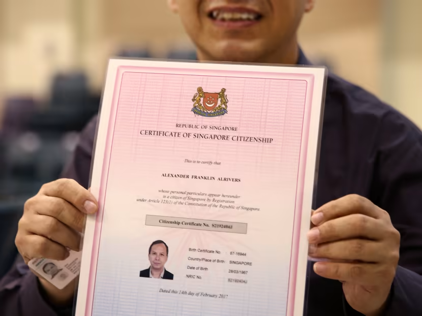 A man holding the Certificate of Singapore Citizenship