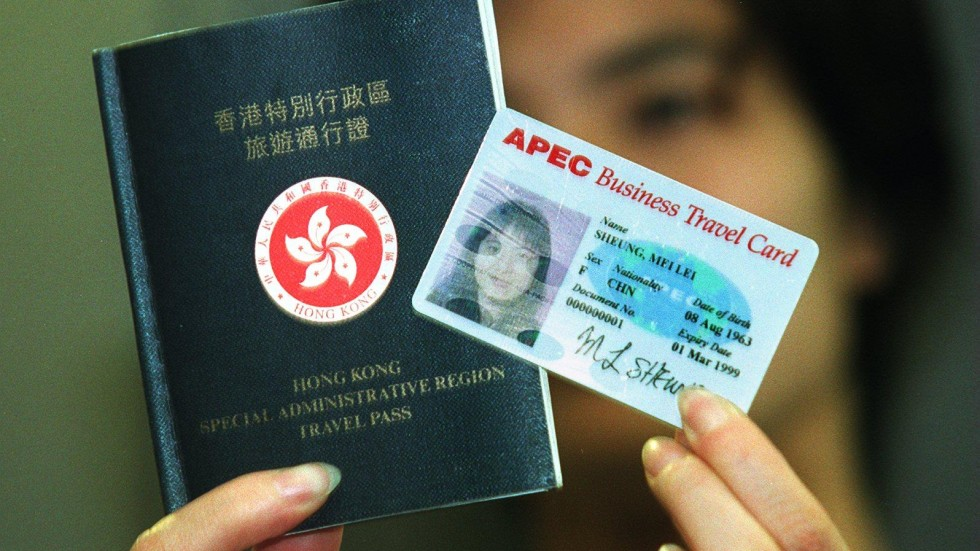 a woman holding an APEC business travel card