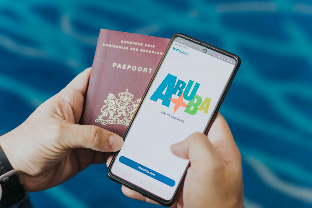 a man is holding a passport and searching for Aruba on his phone